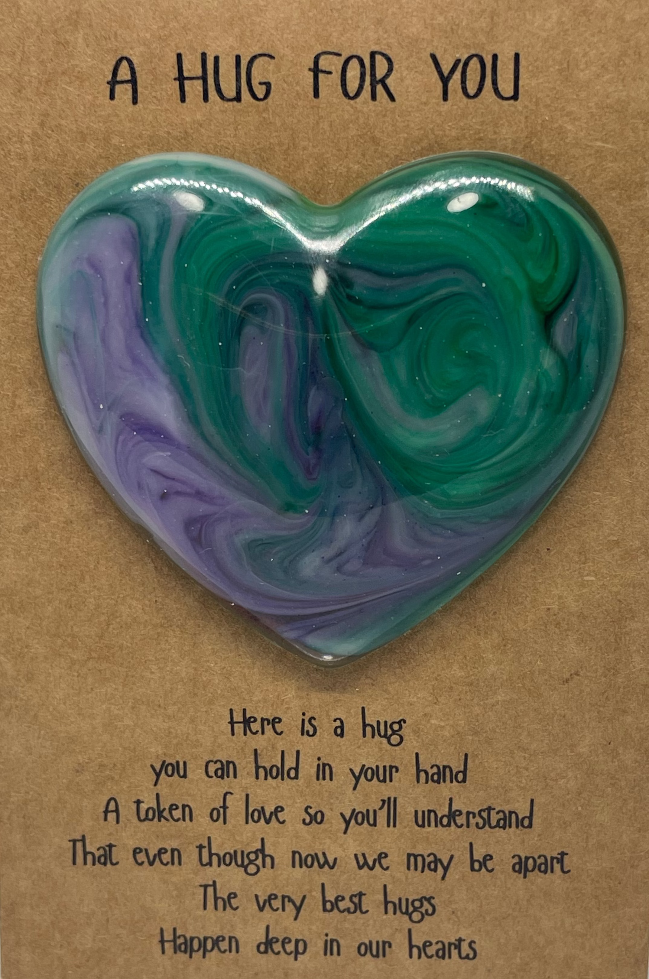 Heart-shaped green and purple heart hug on a brown card with text