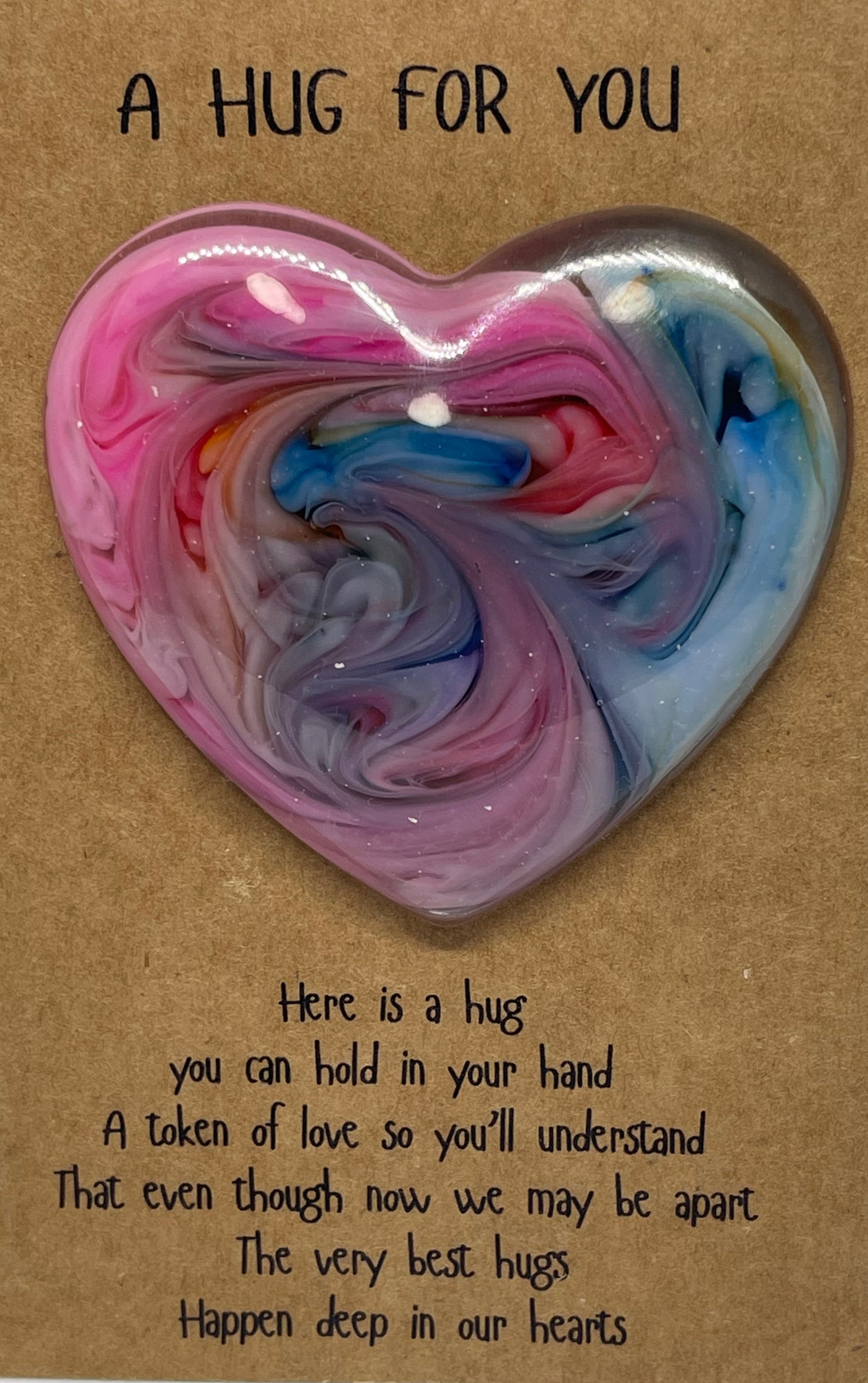 Heart-shaped swirled resin object on a card with text, on a white background