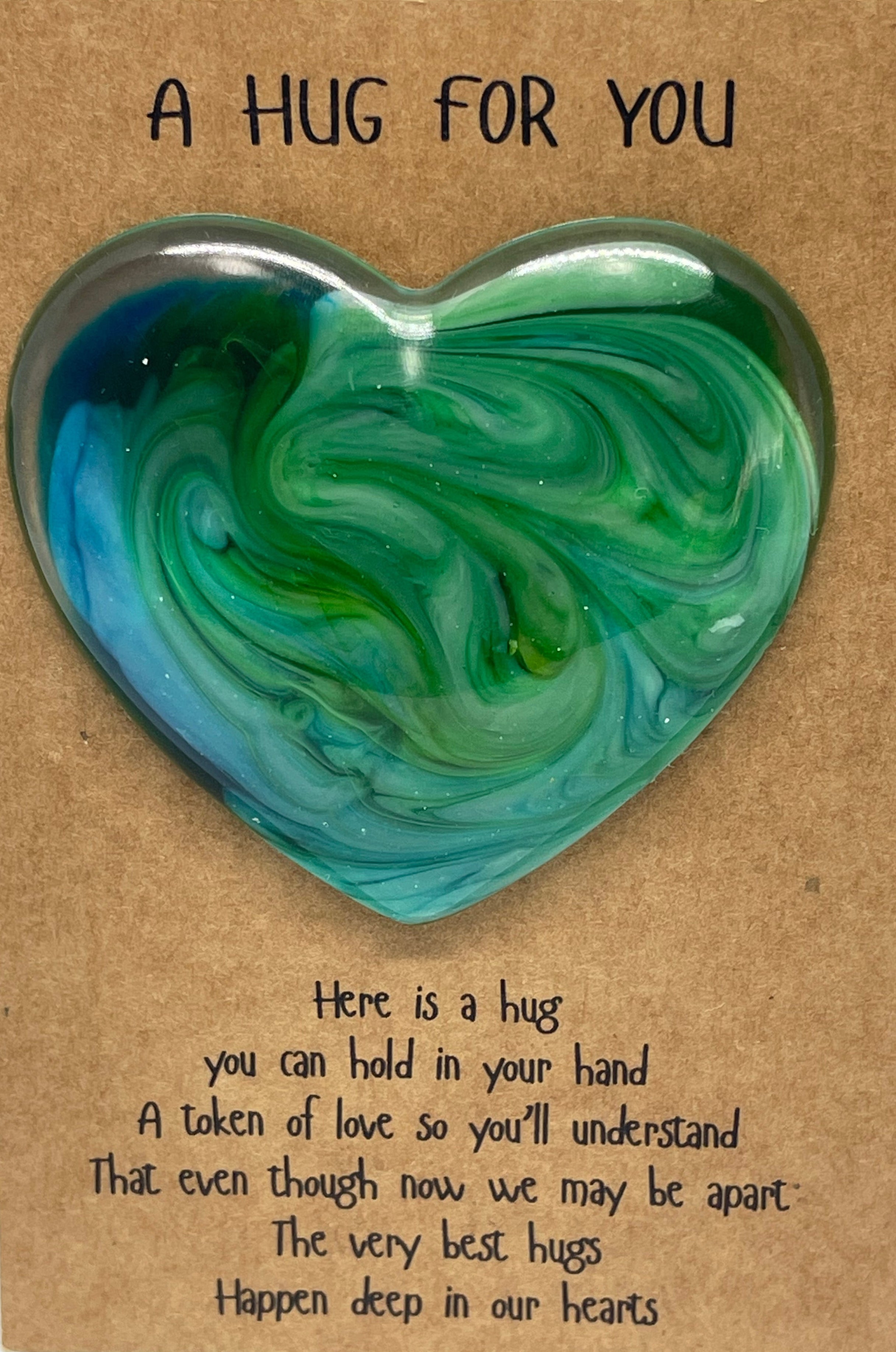 Heart-shaped green and blue marbled heart hug on a brown card with text